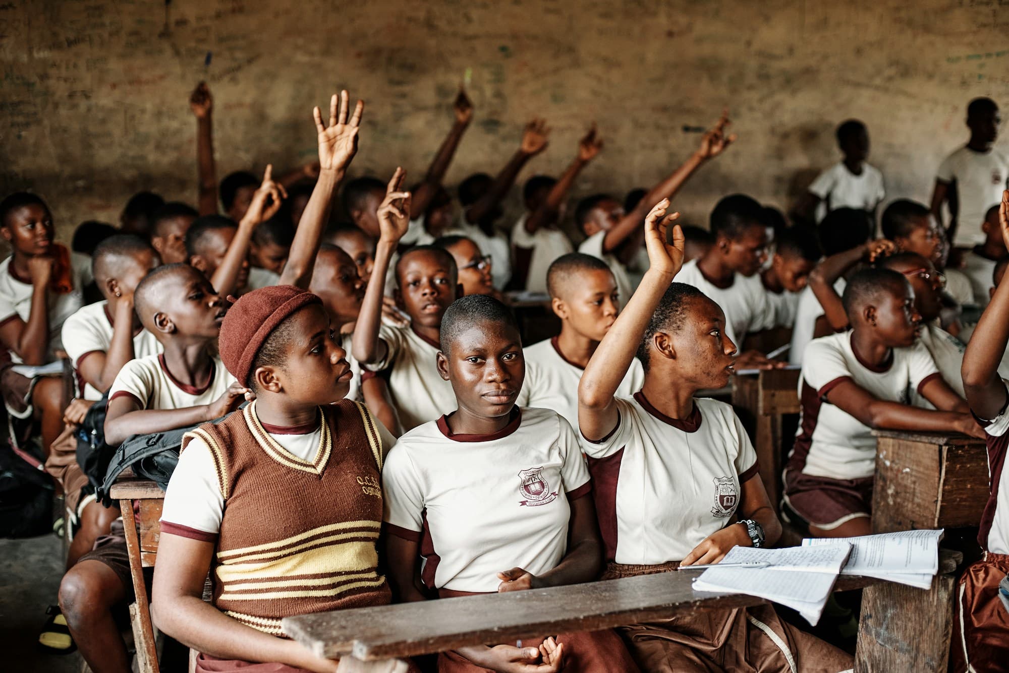 Children raising their hands in a classroom in Nigeria