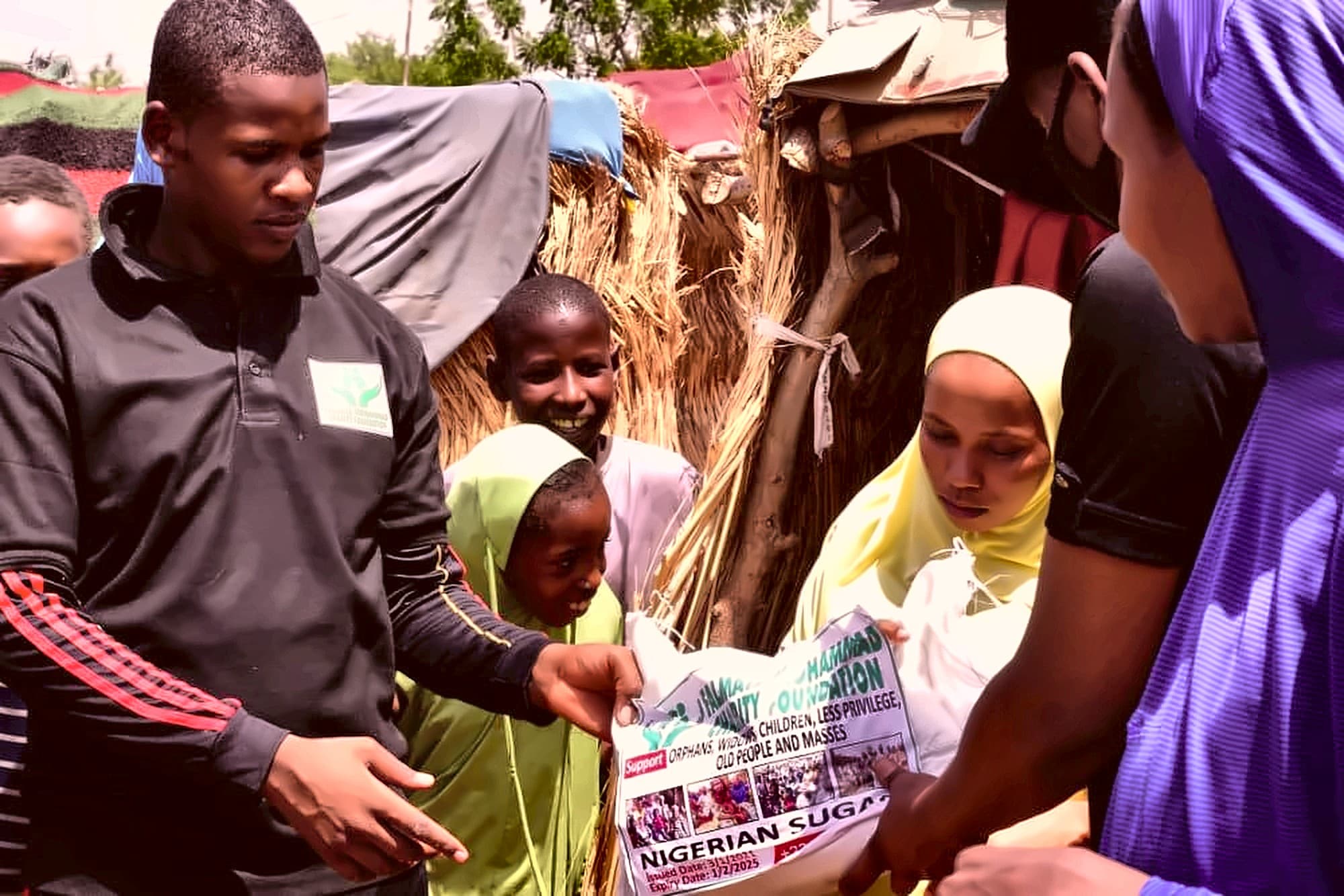 A Dar Al Ayetam volunteer sharing a food parcel with a child